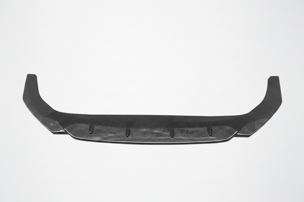 A carbon fiber rear bumper lip spoiler with a carbon fiber weave pattern, shown against a light gray background with a faint graphic outline of two mounting brackets above it.